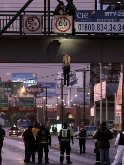 Un grupo de agentes observa el cadáver de Gabriela Elizabeth Muñiz Tamez, alias <i>La Pelirroja</i>, colgado en un puente peatonal sobre una transitada avenida de Monterrey. La Pelirroha lideraba una banda de secuestradores cuando fue detenida en 2009 y hace cuatro días había logrado fugarse de la policía.