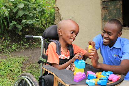 Un niño con hidrocefalia juega con un terapeuta del Kyaninga Child Development Center, en el oeste de Uganda.