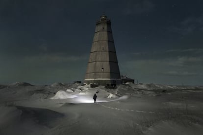 Slava caminha em direção ao velho farol próximo à estação meteorológica de Khodovarikha para retirar a madeira que cobre suas paredes e a usar como lenha.