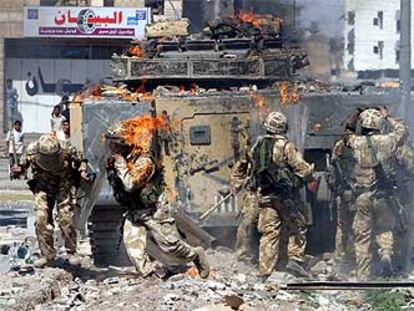 Un soldado británico corre cubierto por las llamas tras las violentas protestas ocurridas ayer en Basora.
