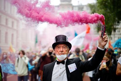 Un activista de Extinction Rebellion agita una bengala durante una protesta en el centro de Londres por el cambio climático.