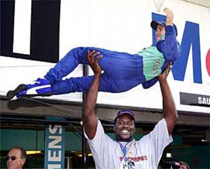 Shaquille O'Neal, estrella de la NBA invitada en el circuito de Hockenheim, levanta al piloto alemán Nick Heifeld.