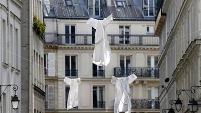 Batas blancas colgadas de una calle de París, este martes, en señal de solidaridad con el personal sanitario.