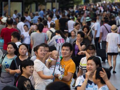 Una familia con un bebé recién nacido se saca un selfi en Shanghái.