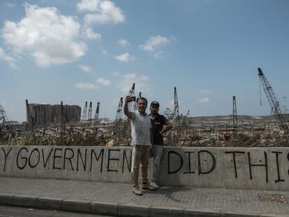 Los libaneses acuden a hacerse un 'selfie' frente a los restos calcinados del puerto de Beirut donde se lee en una pintada: "Mi Gobierno hizo esto".