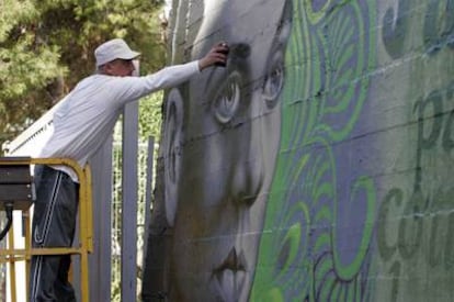 El escritor de <i>graffiti Tom Rock</i> trabaja, ayer, en el retrato de Miguel Hernández.