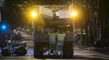 Operarios de FCC recogen muebles y trastos viejos en el distrito del Eixample de Barcelona.