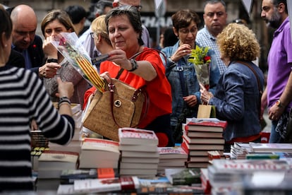Una mujer paga con tarjeta de crédito su compra en una parada de libros en La Rambla de Barcelona durante Sant Jordi.