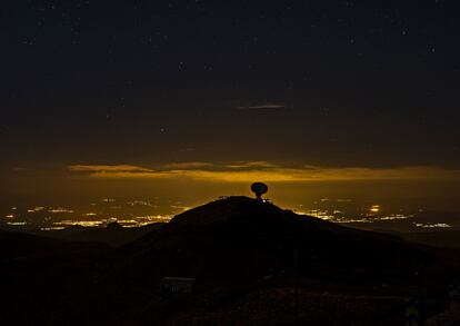 En primer plano, el observatorio que el IAA tiene en Sierra Nevada. Tras él, las luces de Granada en una imagen de 2017.