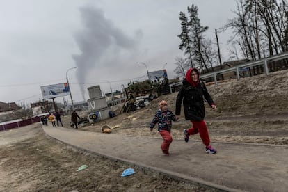 Civiles huyen de los misiles en Irpin, este domingo. La localidad contaba con uno de los dos puentes que da acceso a Kiev y que los propios militares locales dinamitaron la semana pasada para tratar de frenar el avance de las tropas del Kremlin hacia la capital.