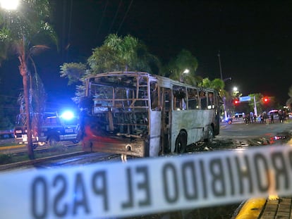 Integrantes de la Policía Municipal resguardan la zona donde fue incendiado un camión de pasajeros en Zapopan, Estado de Jalisco (México), el 9 de agosto.