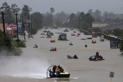 Varios residentes de un barrio de Houston (EE UU) emplean distintas embarcaciones para abandonar la zona inundada debido al paso del huracán Harvey.