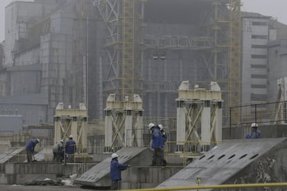 Obreros terminan la primera sección de una enorme estructura en forma de arco destinada a cubrir el reactor nuclear de Chernóbil que estalló en 1983.