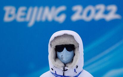 
Tras varios retrasos, finalmente los Juegos Olímpicos de invierno empezarán este viernes 4 de febrero. En la imagen, un voluntario se protege del frío en el parque de nieve Genting, en la ciudad china de Zhangjiakou.