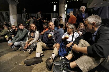 Vecinos esperan a las puertas de la escuela antes de su apertura.