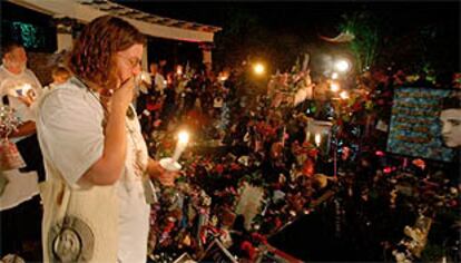 Seguidores de Elvis provistos con velas honran la tumba del cantante en Memphis.