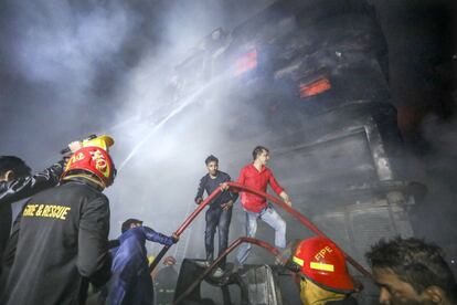 Al lugar del incendio acudieron también el diputado Haji Md Salim y Shayeed Khokon de la alcaldía de la ciudad, para coordinar los esfuerzos de rescate de víctimas y heridos. En la imagen, bomberos y vecinos intentan apagar el incendio.