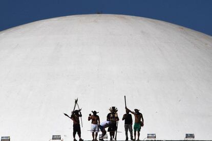 Indígenas de diferentes tribus protestan contra un proyecto de ley que se discute en la Cámara de Diputados de Brasil y que cambia las reglas de demarcación de los territorios indígenas, en la parte superior del edificio del Congreso Nacional en Brasilia.