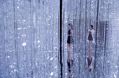 Dos visitantes caminan entre las luces LED de la instalación digital 'Wander through the Crystal Universe' ('Vagar por el universo de cristal') presentado por el colectivo artístico teamLab en el evento 'A World of Wonders' en Tokio (Japón).