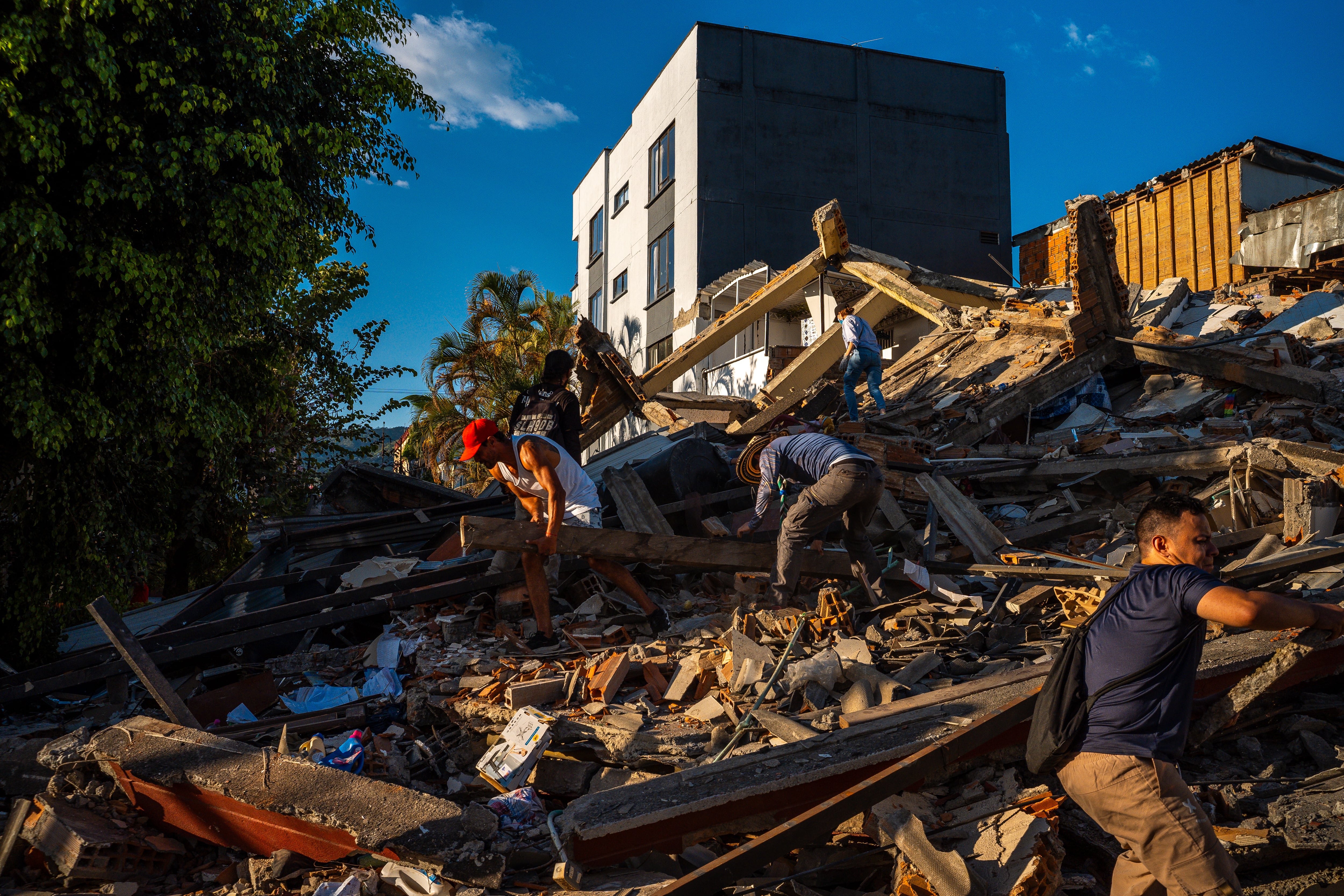 Voluntarios trabajan con autoridades y rescatistas en labores de remoción de escombros y búsqueda de personas atrapadas en los edificios colapsados en Pereira (Colombia), el 10 de agosto.