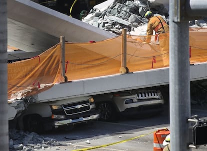 Un puente peatonal se ha derrumbado en torno a las dos de la tarde (hora local) este jueves en Miami y ha caído sobre una autopista de seis carriles dejando a varias personas y vehículos atrapados. En la imagen, vehículos atrapados bajo el puente peatonal.