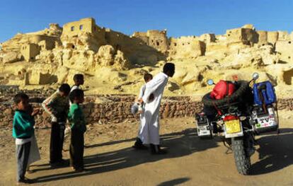 Niños curiosos frente a la vieja ciudadela de Siwa, Egipto, mítico oasis del Oráculo