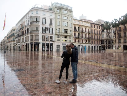 Dos turistas en una desierta calle Larios, en Málaga.