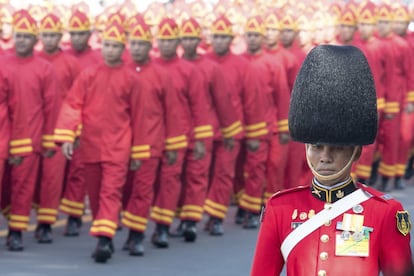 Un guarda de honor y soldados participan en la procesión del funeral.