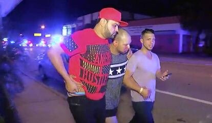 A man injured in the nightclub attack is helped by friends.