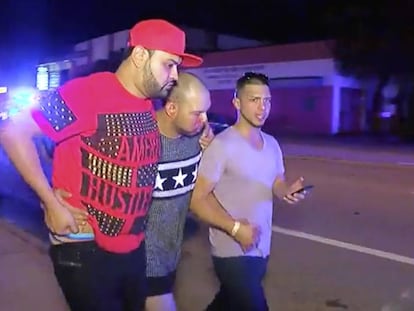 A man injured in the nightclub attack is helped by friends.