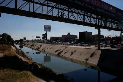 Un adulto y un niño cruzan un puente sobre el canal de Los Remedios, en Ecatepec.