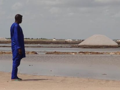 Un hombre mira los dep&oacute;sitos de sal en Kaffrine (Senegal).