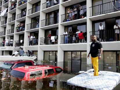 Policías y voluntarios de Nueva Orleans rescatan, con ayuda de una lancha, a vecinos atrapados en un edificio inundado.