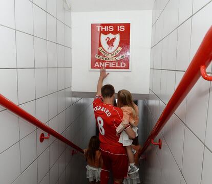 Gerrard, con sus hijas, toca el mítico cartel en el que se puede leer "Esto es Anfield", en el túnel de vestuarios del estadio.