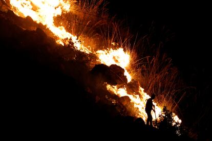 Un hombre intentaba apagar las llamas en la localidad de Altofonte, cerca de Palermo, este miércoles. 
