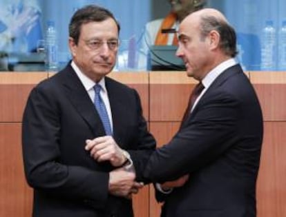 El presidente del Banco Central Europeo (BCE), Mario Draghi (i), y el ministro español de Economía y Competitividad, Luis de Guindos, conversan durante la reunión de los ministros de Finanzas de la UE hoy en Bruselas.