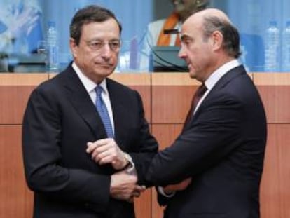 El presidente del Banco Central Europeo (BCE), Mario Draghi (i), y el ministro español de Economía y Competitividad, Luis de Guindos, conversan durante la reunión de los ministros de Finanzas de la UE hoy en Bruselas.