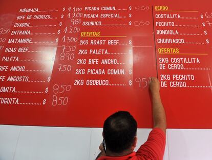 Un hombre actualiza los precios de los productos en un mercado en Buenos Aires.