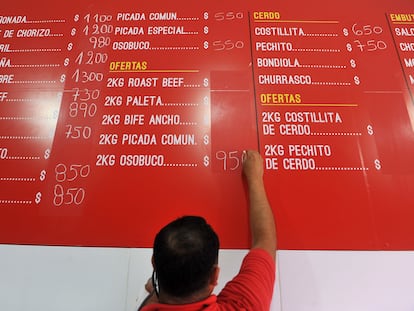 Una persona coloca en una pizarra nuevos precios para la carne en un mercado de Buenos Aires, en enero de 2022.