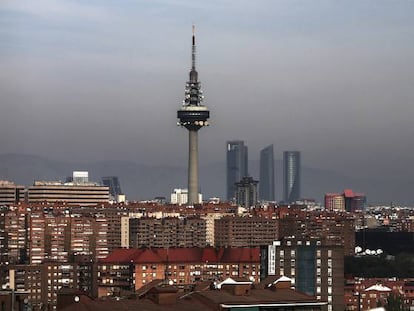 Un hombre con su beb&eacute; pasea por el barrio de Entrev&iacute;as, en Madrid.