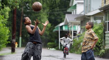 Dois garotos jogam basquete em uma rua de Akron.