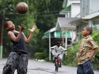 Dois garotos jogam basquete em uma rua de Akron.