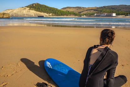 Una surfista descansa en la concha de arena que comparten Plentzia y Gorliz, en Bizkaia.