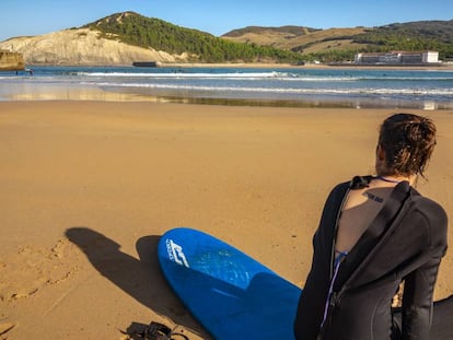 Una surfista descansa en la concha de arena que comparten Plentzia y Gorliz, en Bizkaia.