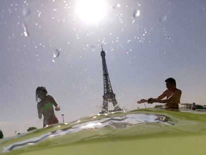 Dos personas se bañaban este jueves en una fuente cercana a la Torre Eiffel, en París.