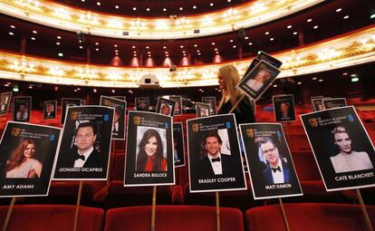 Personal de producción coloca los carteles donde se sentaran los actores en la gala de los  premios Bafta que se celebrara en la Royal Opera House en Londres.