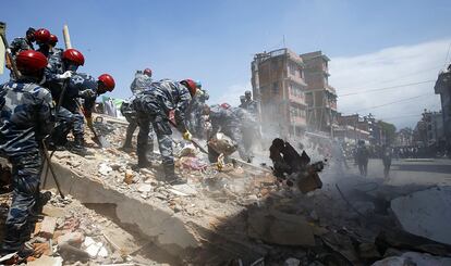 Policías buscan supervivientes entre los escombros tras el derrumbe de un edificio durante el terremoto de 7,3 grados en la escala Richter en Katmandú (Nepal), el 12 de mayo de 2015.