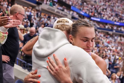 Sabalenka hugs a member of her team.