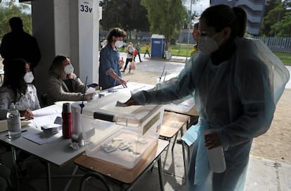 Buena parte del oficialismo apoya la confección de un nuevo texto. En la imagen, un mujer limpia una de las urnas como protección frente al a pandemia de la covid.