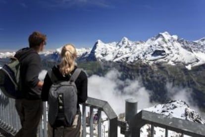 Dos turistas contemplando las cimas del Eiger, Monch y Jungfrau desde el mirador de Schilthorn, en los Alpes suizos.